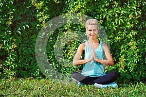 Happy woman sitting in padmasana yoga pose