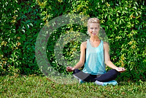 Happy woman sitting in siddhasana yoga pose