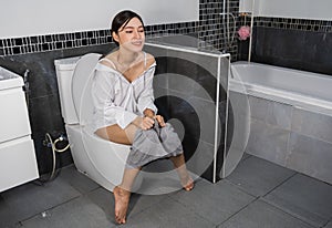 Happy woman sitting on a toilet