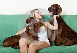 Happy woman sitting with two Irish setters