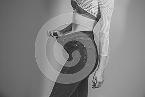 Happy woman. Slim waist of young female in big jeans