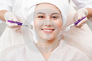 Happy woman with smile use facial treatment mask on skin face in spa beauty salon