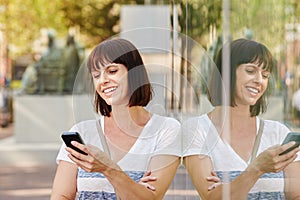 Happy woman smiling with cellphone outside