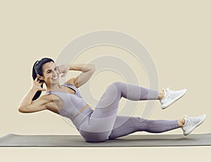 Happy woman smiling while doing crunches exercise during sports workout at the gym