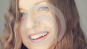 Happy woman smiling and laughing, long brown wavy hair, natural make-up and healthy white teeth, face and beauty