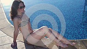 Happy woman smiling, lying by swimming pool, enjoying sunlight