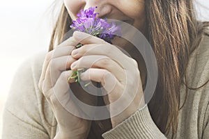 Happy woman sniffs a small bouquet of flowers, springtime