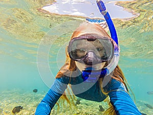 Happy woman in snorkeling mask dive underwater with tropical fishes in coral reef sea pool. Travel lifestyle, water