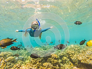 Happy woman in snorkeling mask dive underwater with tropical fishes in coral reef sea pool. Travel lifestyle, water
