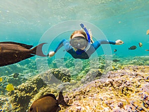 Happy woman in snorkeling mask dive underwater with tropical fishes in coral reef sea pool. Travel lifestyle, water