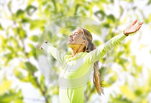 Happy woman in sport clothes raising hands