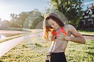 Happy woman in sportswear demonstrate press with cubes in green sunny park.