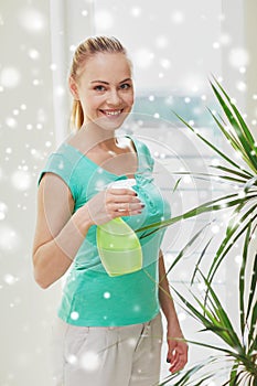 Happy woman in spraying houseplants at home