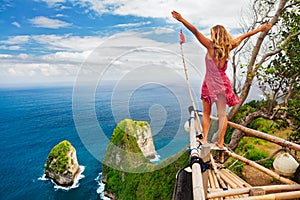 Happy woman stand at high cliff viewpoint, look at sea