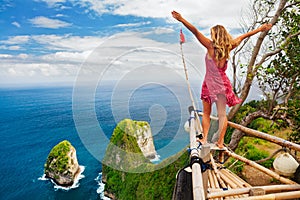 Happy woman stand at high cliff viewpoint, look at sea photo