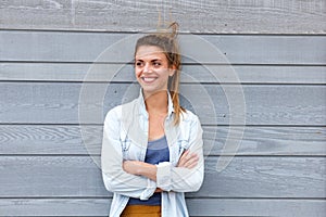 Happy woman standing with arms crossed and hair blowing