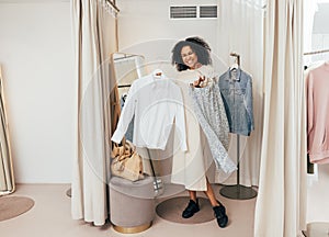 Happy woman standing with clothes in fitting room