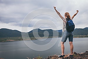 Happy woman standing near the lake at the day time