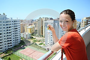 Happy woman stands on balcony