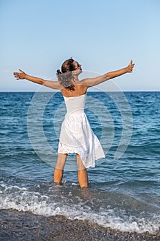 Happy woman stays in a sea water. photo