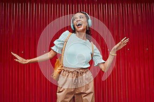 Happy woman streaming music, singing and hip hop dance on stage with headphones. Young musical performer, fun and energy