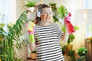 Happy woman in striped shirt in sunny day housecleaning