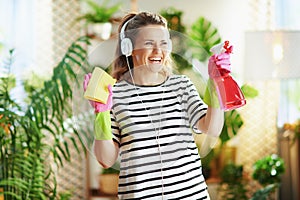 Happy woman in striped shirt in sunny day housecleaning photo