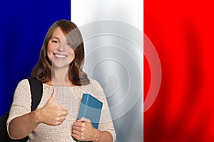 Happy woman student against French flag background. Travel, education and learn language in France concept