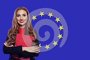 Happy woman student with book against the European Union flag background