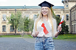 Happy woman student graduate with Poland flag and diploma.