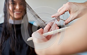 Happy woman with stylist cutting hair at salon