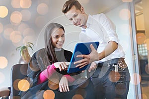 Happy woman and stylist with tablet pc at salon