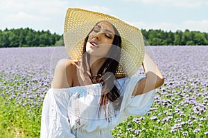 Happy woman in summer field. Young girl relax outdoors. Freedom concept.