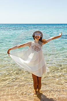 Happy woman in summer white dress on beach. girl relaxing and enjoying peace on vacation