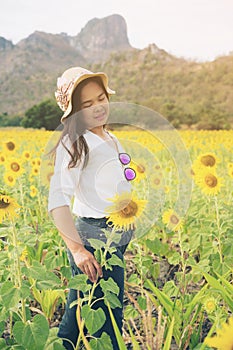 Happy woman in sunflower field smiling with happiness