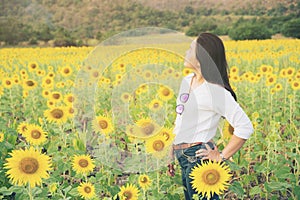 Happy woman in sunflower field smiling with happiness