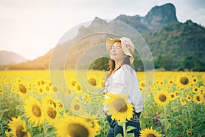 Happy woman in sunflower field smiling with happiness