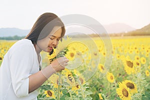 Happy woman in sunflower field smiling with happiness