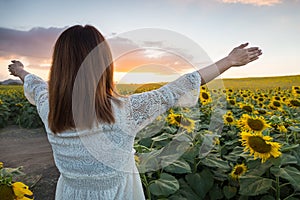 Happy woman in sunflower field. Summer girl in flower field cheerful. Asian Caucasian young woman raise arm OK and freedom show in