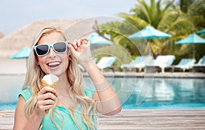 Happy woman in sunglasses with ice cream on beach