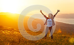 Šťastný žena na západ slnka v príroda otvoriť ruky 