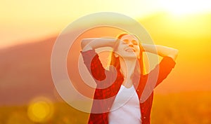 Happy woman on sunset in nature iwith open hands