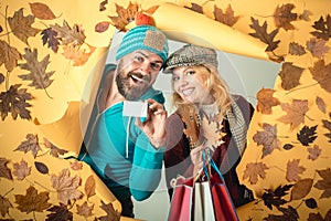 Happy woman and surprised man on Autumn background. Autumn copy space for trend vogue. Happy couple go shopping on black