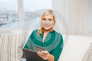 Happy woman with tablet pc and credit card