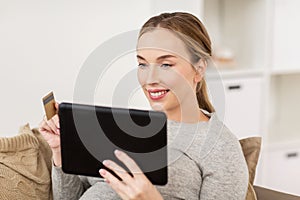 Happy woman with tablet pc and credit card