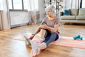 happy woman with tablet pc exercising at home