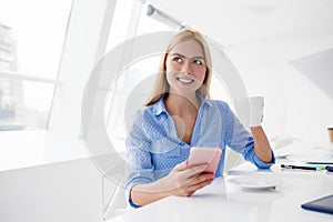 Happy woman takes a coffee break during her work