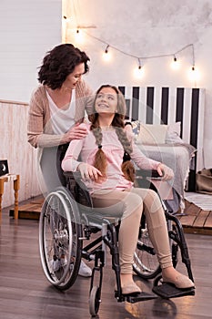 Happy woman taking care of disabled girl