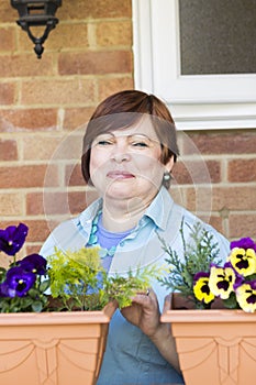 Happy woman taking care of flowers outdoors