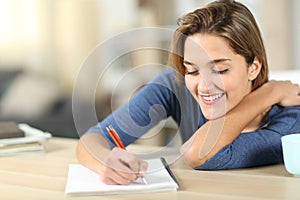 Happy woman taking notes at home